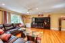 Inviting living room featuring rich hardwood floors, warm neutral walls, and a large picture window that fills the space with natural light. The room 