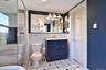 Tiled bath with glass-enclosed shower.