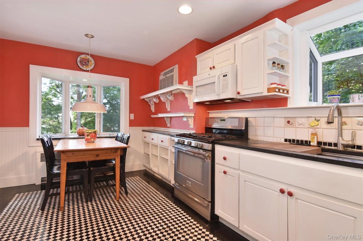 Kitchen with decorative black and white tile floor and seating area.