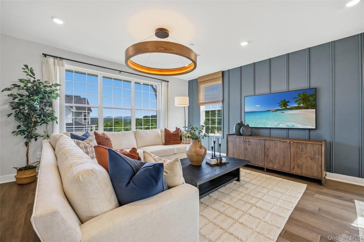 Spacious living area featuring large windows with wood-finish flooring.