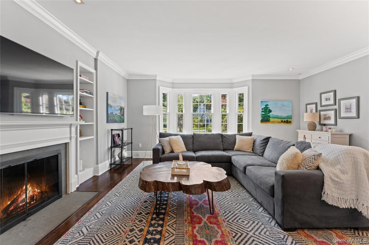 Large living room with a gas fireplace, built-in shelving and set beautifully with windows overlooking the gorgeous landscape. Exceptional for enterta