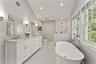 Spa-like primary bathroom with radiant heated floors, soaking tub, double vanities and shower