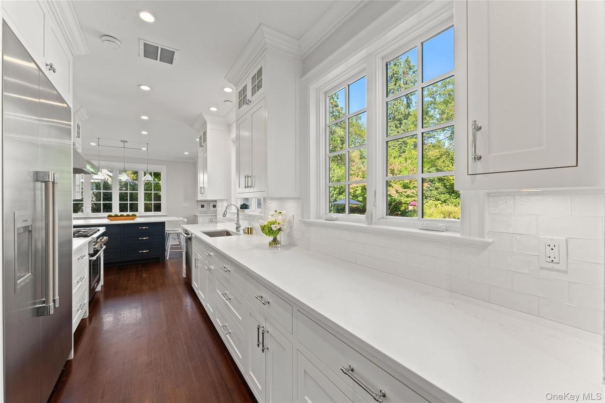 Sunlit and spacious updated kitchen with extensive counter space and custom cabinetry