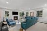 Fireplace with a black hearth and mantle, recessed lighting, and multiple windows with white trim