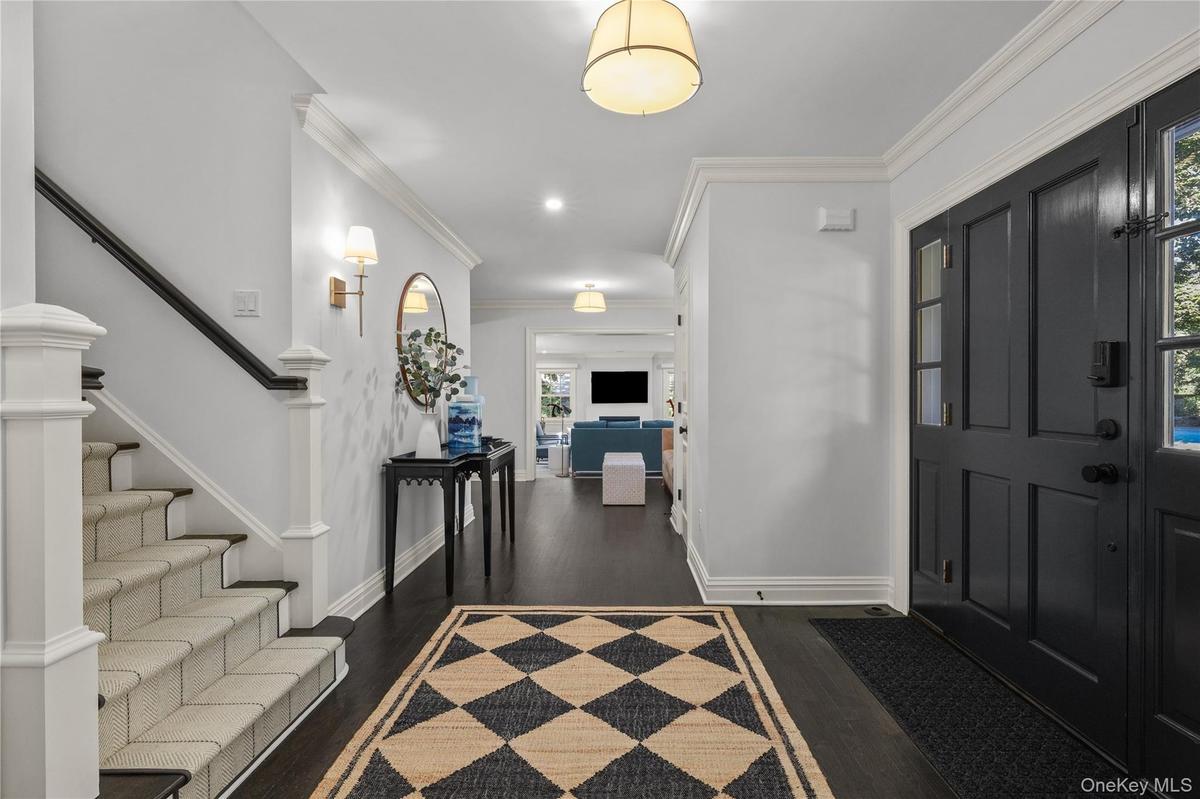 Dark wood-finish flooring with a contrasting staircase featuring white risers and a dark handrail