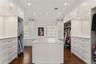 Primary bedroom his-and-hers updated walk-in closet with extensive custom cabinetry and storage