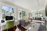 Impressive window-lined sunroom with a gas fireplace offers seamless views of the surrounding landscape