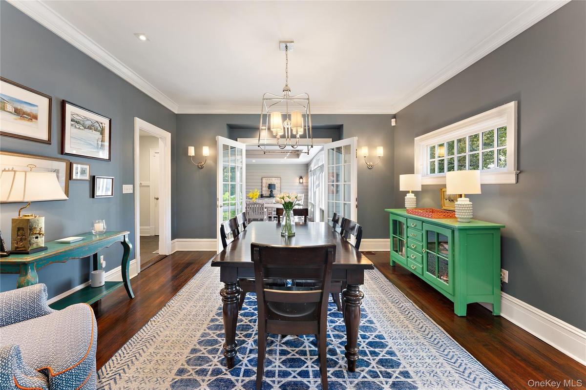 Spacious dining room with french doors leading to the window-lined porch/breezeway for easy entertaining