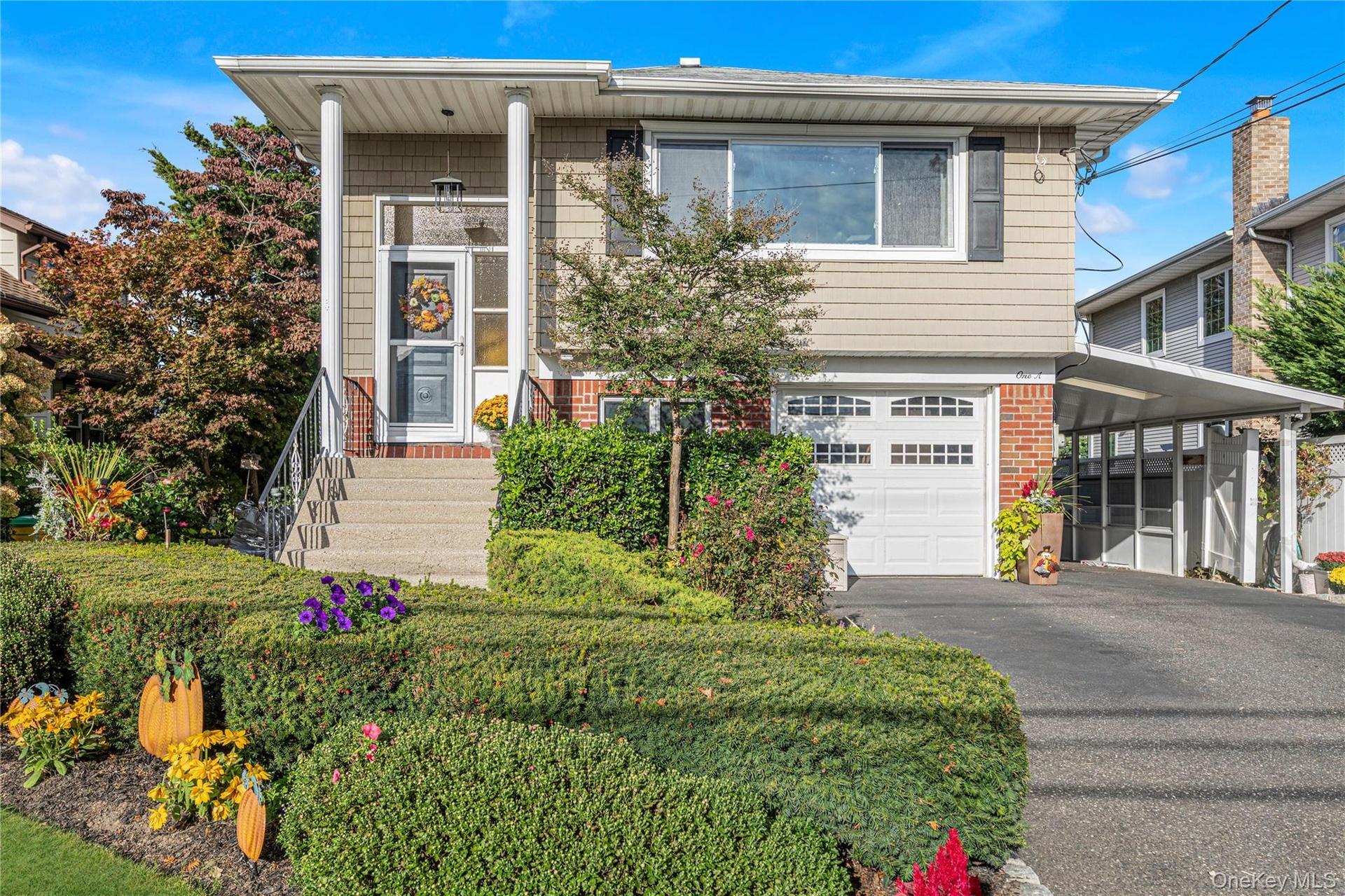 Front of the home with attached garage and carport