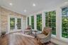 At the top of the stairs is this charming windor wrapped space with French doors to yard