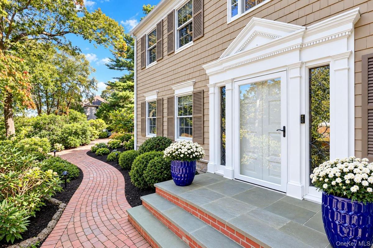 Welcoming Front Entrance With Brick Walkway & Bluestone Steps