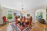 Dining room with hanging lights, light wood-type flooring, arched walkways, and vaulted ceiling