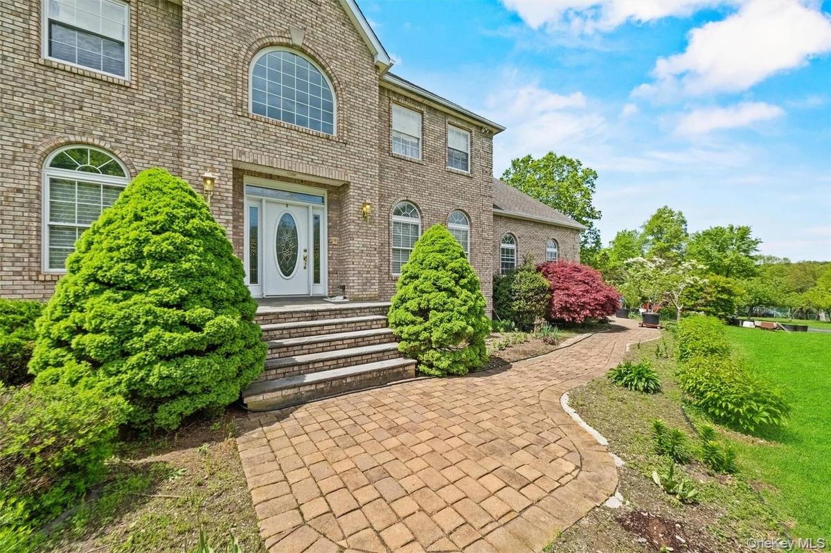 Property entrance with brick siding and a lawn