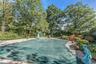 View of home's community featuring view of scattered trees, a patio area, and a swimming pool