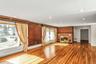 Unfurnished living room featuring a brick fireplace, radiator heating unit, wood finished floors, recessed lighting, and baseboard heating