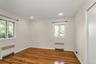Empty room with radiator heating unit, dark wood-style flooring, and recessed lighting