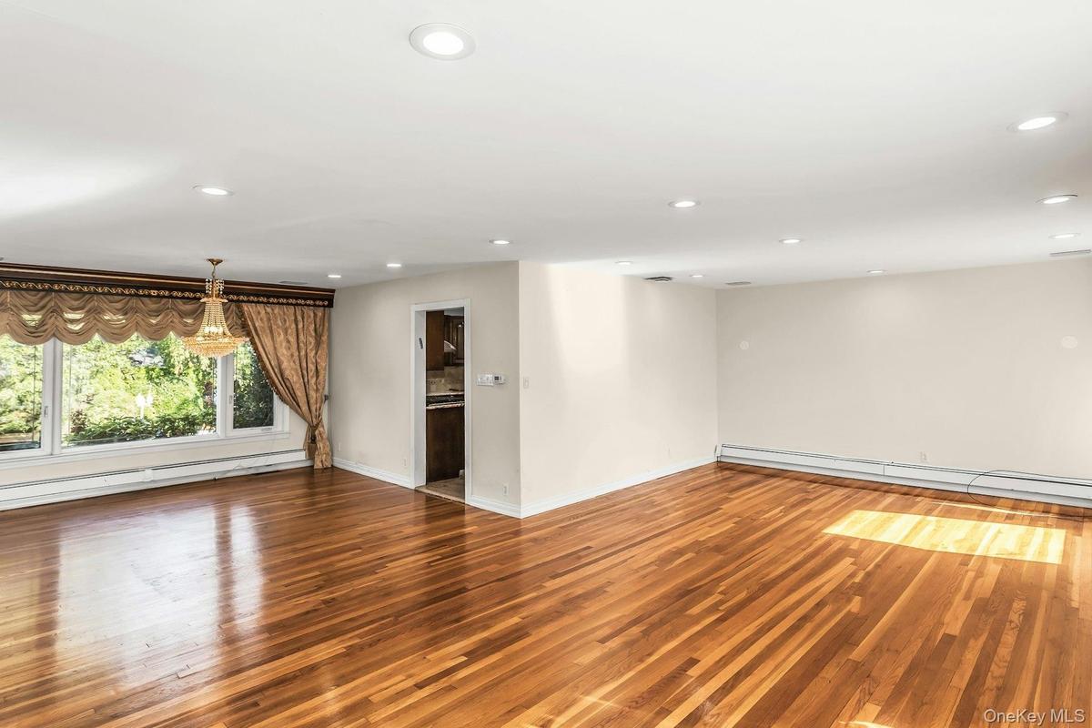 Unfurnished room featuring light wood-style floors, recessed lighting, a baseboard heating unit, and a baseboard radiator