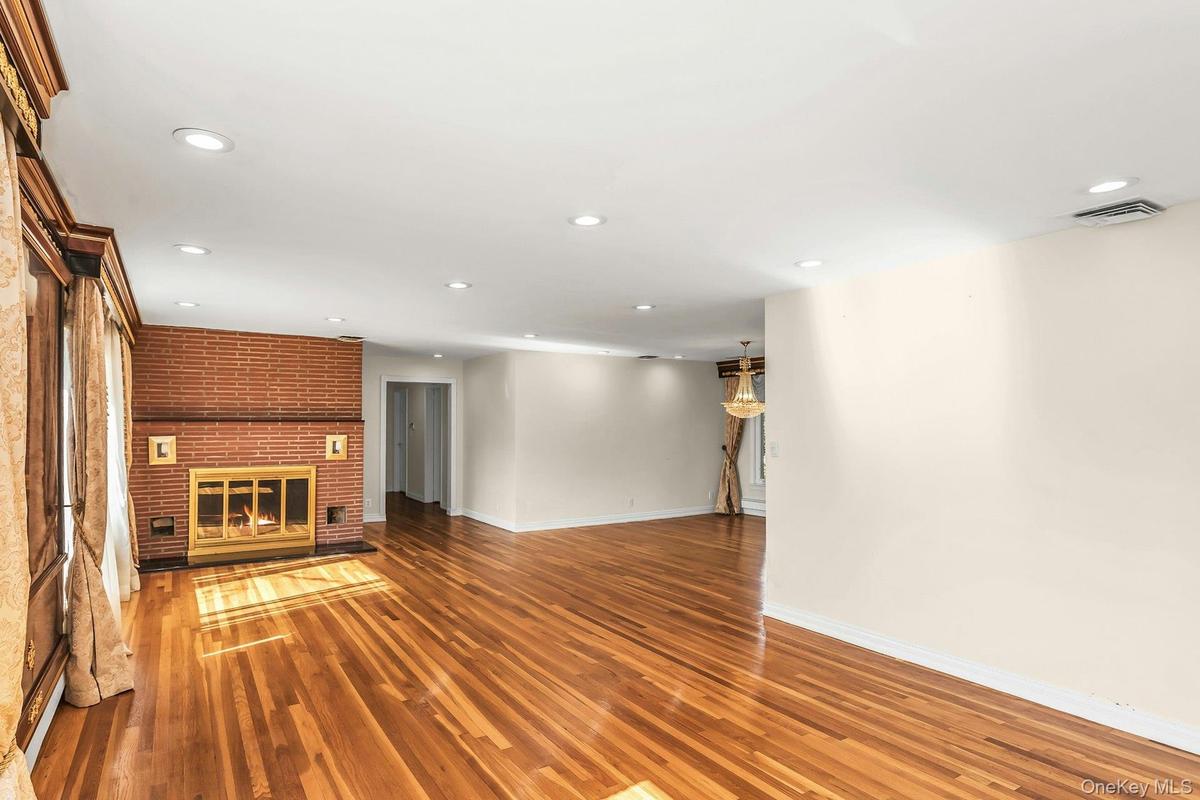 Unfurnished living room with recessed lighting, a fireplace, and wood finished floors