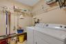 Dedicated laundry area featuring white washer and dryer, extensive wire shelving, and neutral wall paint