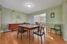 Hardwood flooring, chair rail molding, ceiling light fixture, and an open entryway to an additional room