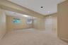 Spacious room featuring neutral new carpeting, recessed lighting, and two windows