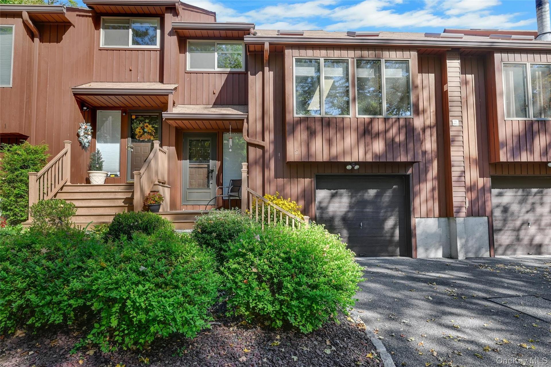 Wood-sided exterior with multiple windows and an attached garage