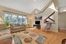 Vaulted ceiling, wood-finish flooring, large windows, wood staircase, and skylights