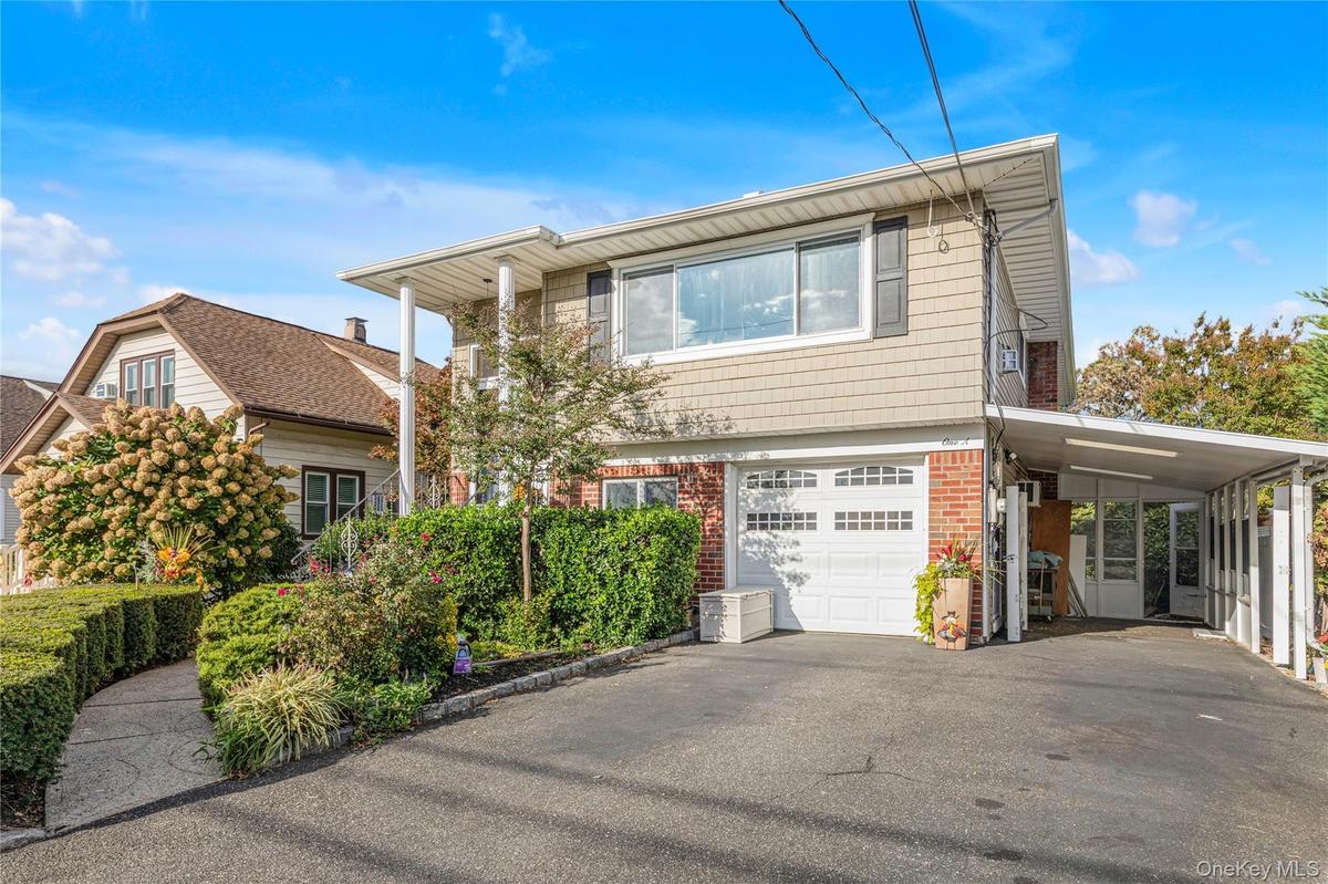Front of the home with attached garage and carport