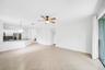 Open-concept living area with tile flooring, a ceiling fan, and sliding glass doors