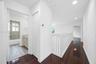 Hallway featuring dark wood-finish flooring, white baluster railing, and recessed lighting
