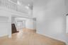 Two-story interior featuring a second-level open railing, recessed lighting, and a chandelier-style fixture