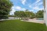 Expansive green lawn with a black metal fence