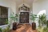 Arched entry with a double-door entry, transom window, and brick paver walkway