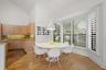 Vaulted ceiling, wood-finish flooring, bay window with plantation shutters, wood cabinetry, and granite countertops