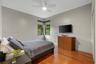Hardwood-finish flooring, corner windows with roller shades, and a ceiling fan with integrated lighting