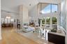 Expansive living area featuring vaulted ceilings, a stone-clad fireplace, and large sliding glass doors