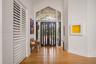 Double entry doors with vertical glass panels, hardwood flooring, and a large architectural transom window
