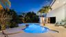 Curved swimming pool with integrated spa and stone waterfall feature