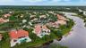 Waterfront property with a private swimming pool, terracotta tile roof, and mature landscaping