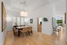Wood-finish flooring throughout, featuring a tray ceiling, recessed lighting, and plantation shutters