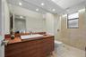 Floating wood-finish vanity with a vessel sink and chrome faucet