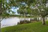 Expansive water feature with natural vegetation and surrounding green space