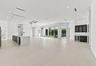 Expansive open-concept living space featuring light-toned polished concrete flooring throughout