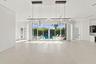 Expansive open-concept room with light-toned flooring and multiple floor-to-ceiling glass sliding doors