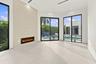 Bright, open-concept living space featuring polished concrete flooring, recessed ceiling lighting, and a linear electric fireplace with black surround