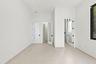 Bright, open interior featuring multiple white panel doors with black hardware, neutral flooring throughout, and clean white walls with recessed ceili
