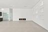 Built-in linear fireplace, recessed wall niches with accent lighting, dark wood-finish cabinetry, light-toned flooring, and recessed ceiling lighting