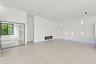 Spacious open-concept room featuring polished concrete flooring, recessed ceiling lighting, and a linear electric fireplace
