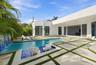 Modern poolside oasis featuring a resort-style saltwater pool with integrated spa seating, geometric concrete decking with contrasting grass inlays, a