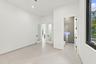 Bright, open primary suite featuring polished concrete flooring, multiple glass-panel French doors with black hardware, recessed ceiling lighting, and